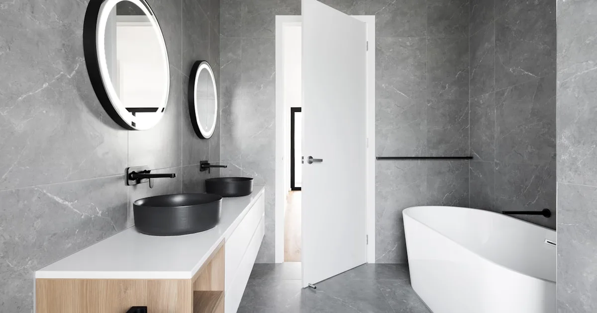 Salle de bains luxe avec baignoire îlot blanche et carrelage marbre gris